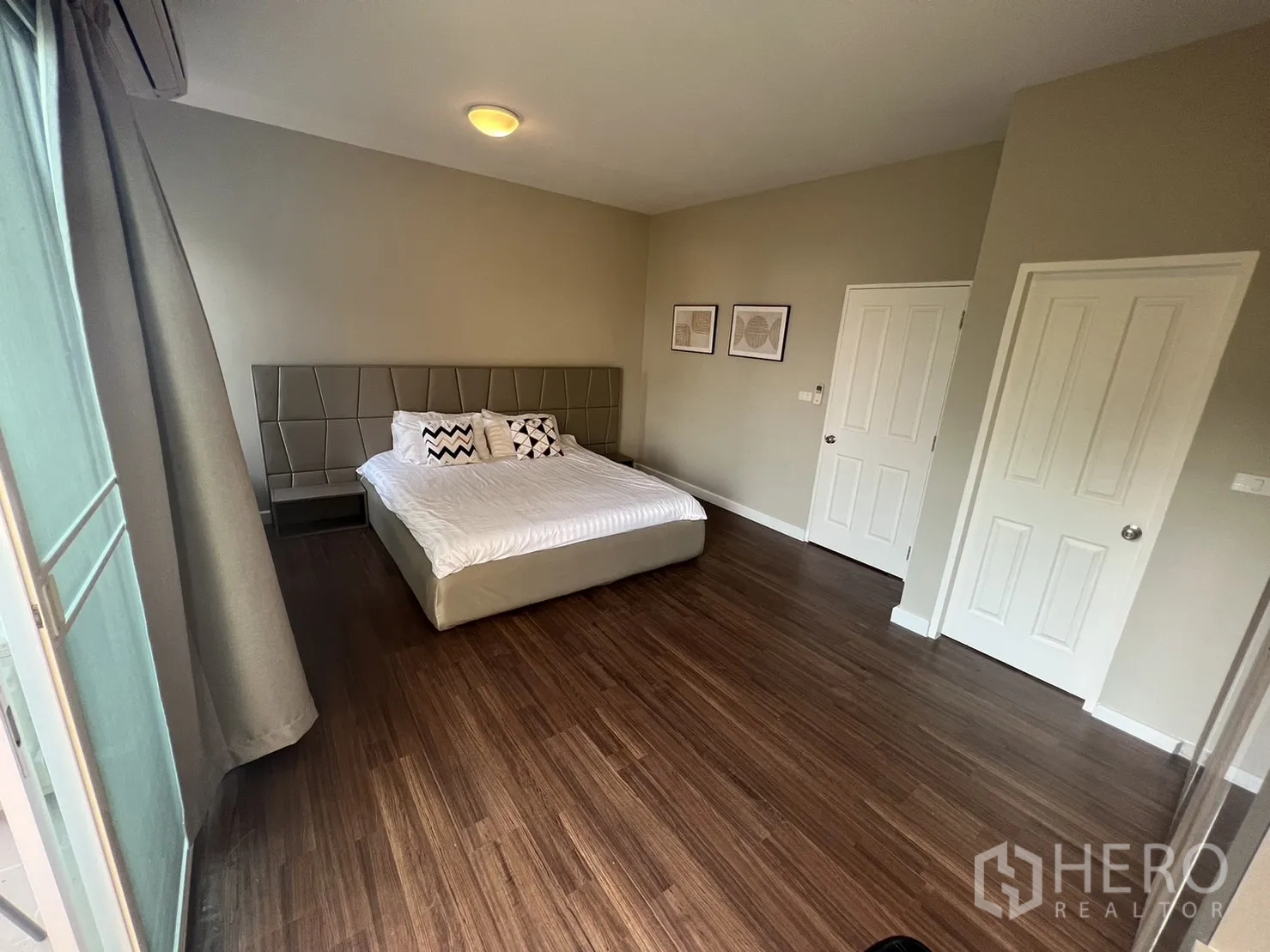 联排别墅 for rent in Suan Luang, Bangkok - 大型主卧，木纹地板与中性色调。