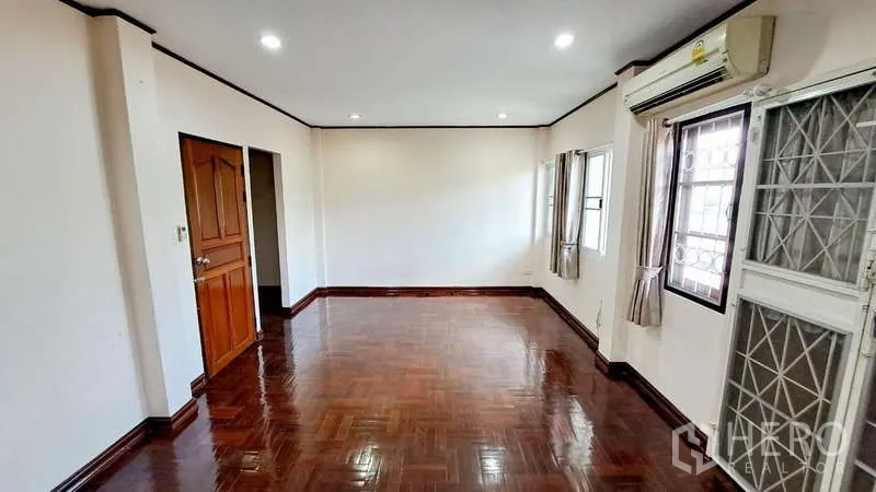 联排别墅 出租在Watthana, Bangkok - 另一角度的明亮房间，木地板、空调与采光窗