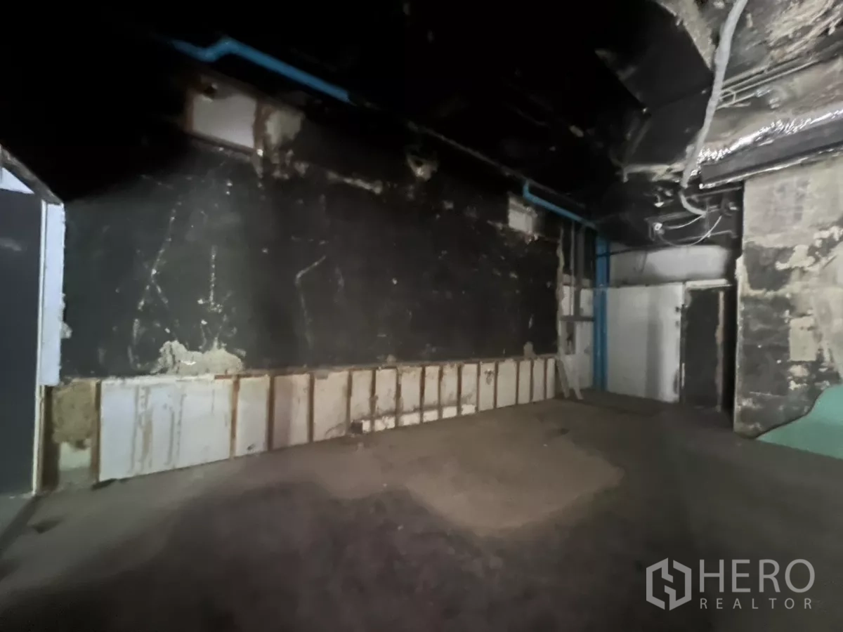 Retail Space for rent in Khlong Toei, Bangkok - Back room with black walls, blue plumbing and space for storage or utilities.