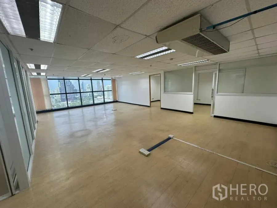 Office Space for rent - Spacious office floor with wall-mounted AC unit, internal glass rooms and bright natural light.