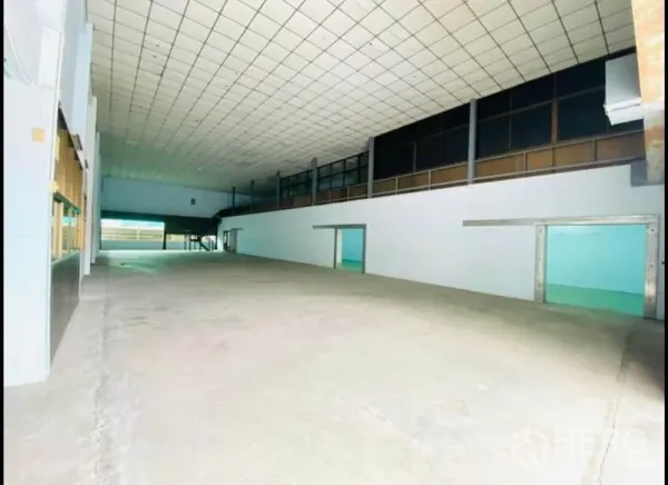 Factory for rent in Sam Phran, Nakhon Pathom - Wide storage bay with mezzanine offices and smooth concrete flooring.