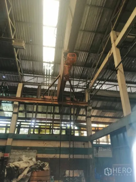 Factory for rent in Lam Luk Ka, Pathum Thani - Overhead chain hoist and crane beam beneath skylight panels inside the factory.