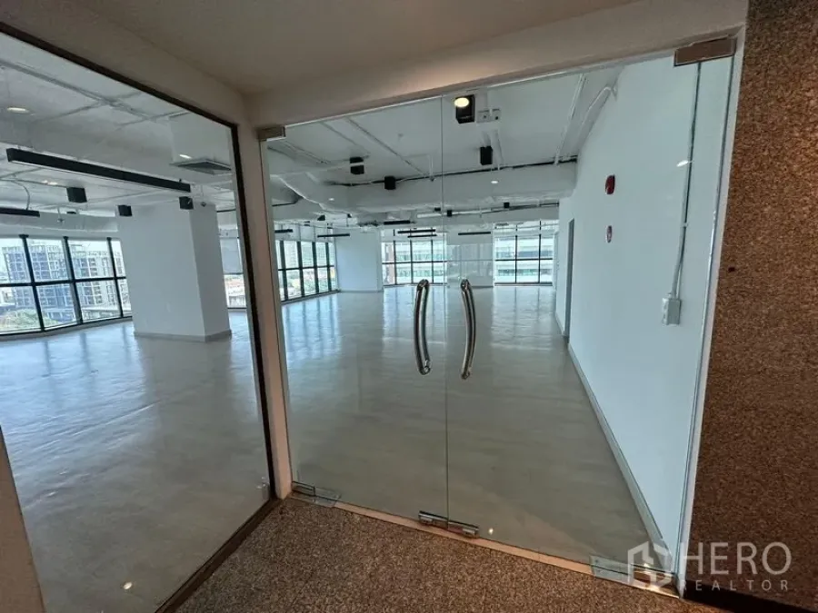 Office Space for rent - Glass double‑door entrance opening to a bright office with panoramic city views.