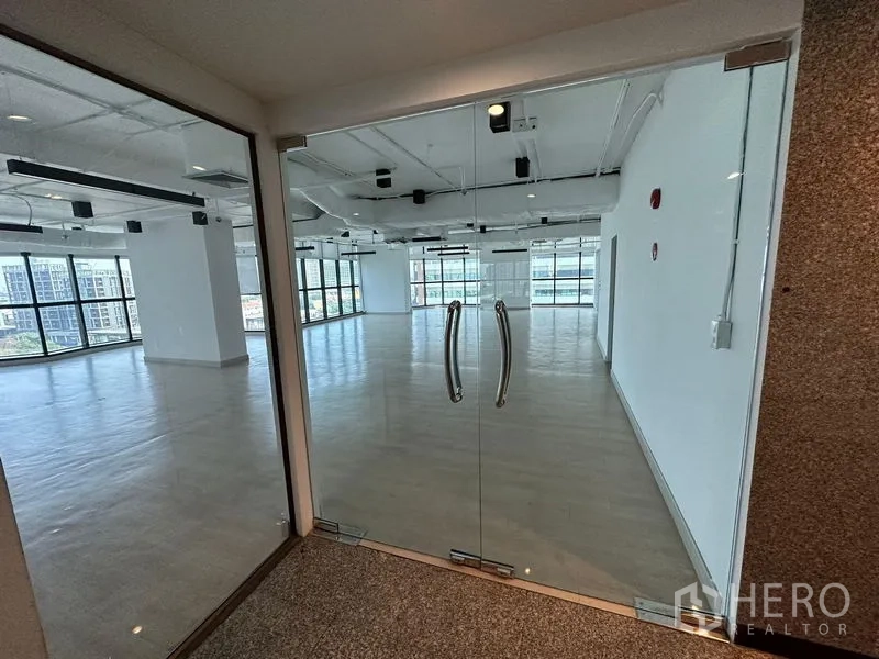 Office Space for rent - Glass double‑door entrance opening to a bright office with panoramic city views.