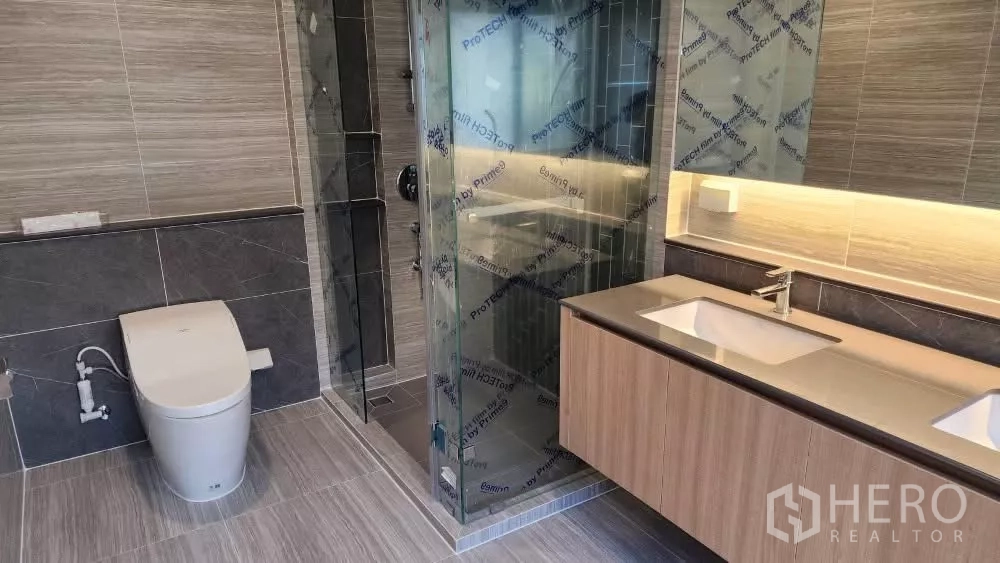 Detached House for rent or sale in Bang Kapi, Bangkok - Bathroom with glass-enclosed shower, smart toilet and twin sinks.