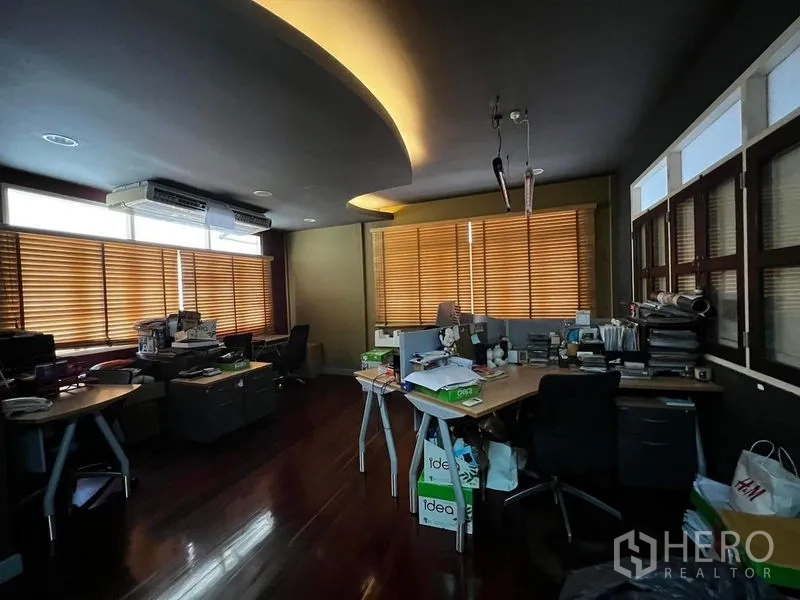 Townhouse for rent - Open-plan office with curved ceiling lighting, blinds and workstations.