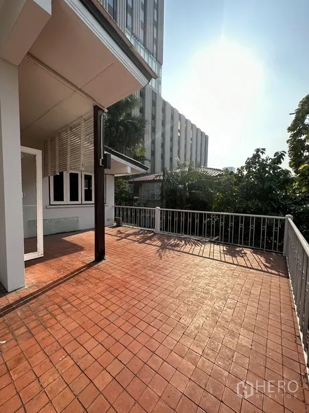 Detached House for rent in Phaya Thai, Bangkok - Large tiled terrace on the upper floor with railing and city views.