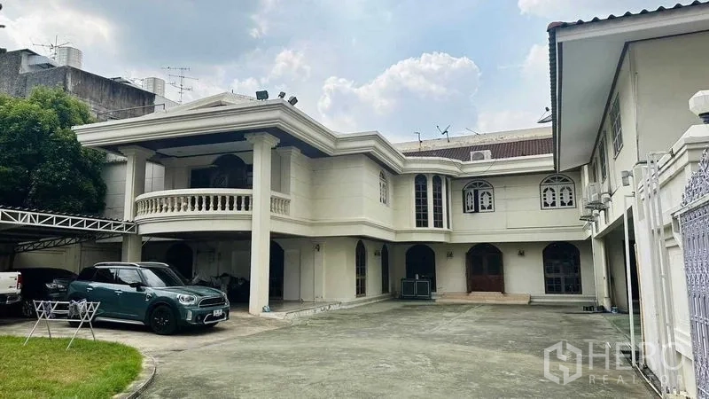บ้าน ขายในHuai Khwang, Bangkok - บ้านเดี่ยวสองชั้นสไตล์คลาสสิก ระเบียงเสาคอลัมน์ หน้าต่างโค้ง และลานหน้าบ้านกว้างจอดรถได้หลายคัน ในห้วยขวาง กรุงเทพฯ