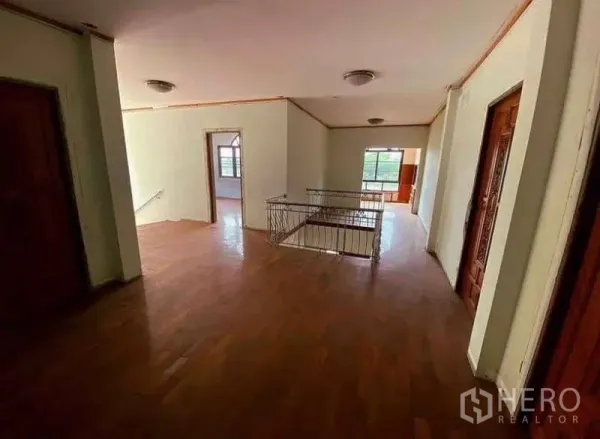Detached House for sale in Prawet, Bangkok - Upper floor landing with wood floors and several bedrooms off the corridor.