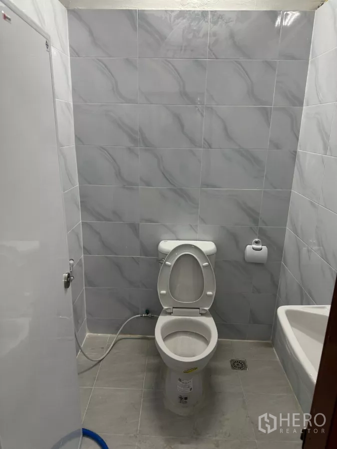 Warehouse for rent in Bang Khun Thian, Bangkok - Compact washroom with toilet and fully tiled walls.