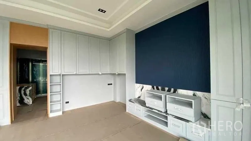 Detached House for sale in Mueang Nonthaburi, Nonthaburi - Bedroom with full‑height wardrobes, blue accent panel and custom media cabinet.
