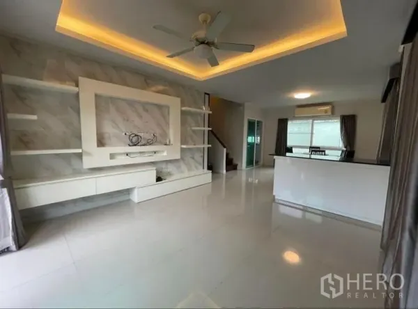 Detached House for sale in Bang Phli, Samut Prakan - Bright open-plan living room with tray ceiling lights, ceiling fan and built-in TV wall.