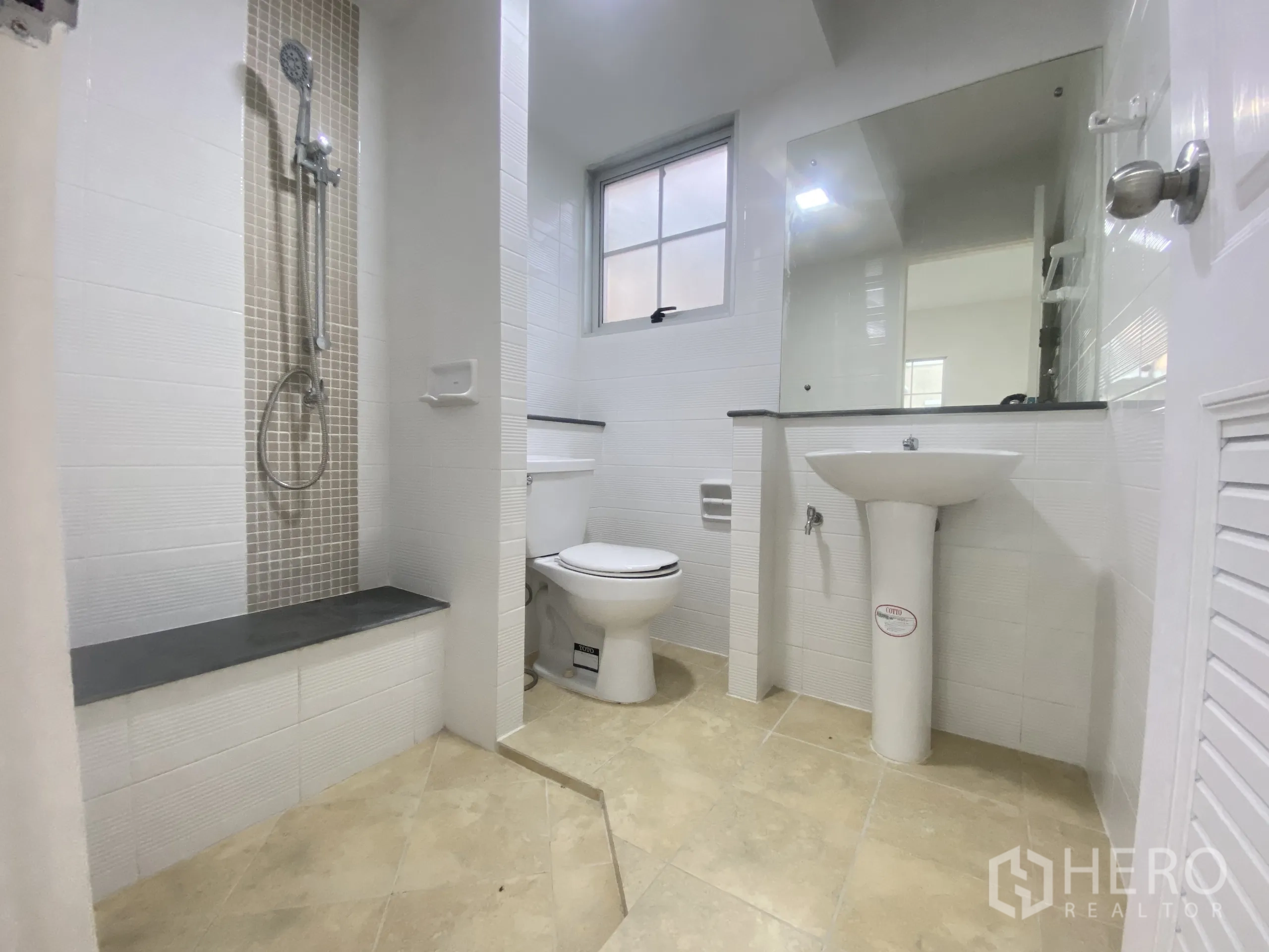 Detached House for sale in Nonthaburi - Modern bathroom with walk-in shower, pedestal sink, toilet and beige floor tiles.
