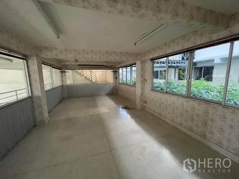 店屋 出租在Khlong Toei, Bangkok - 封闭办公室，四周落地窗与浅色墙面，可见外部花园景观。