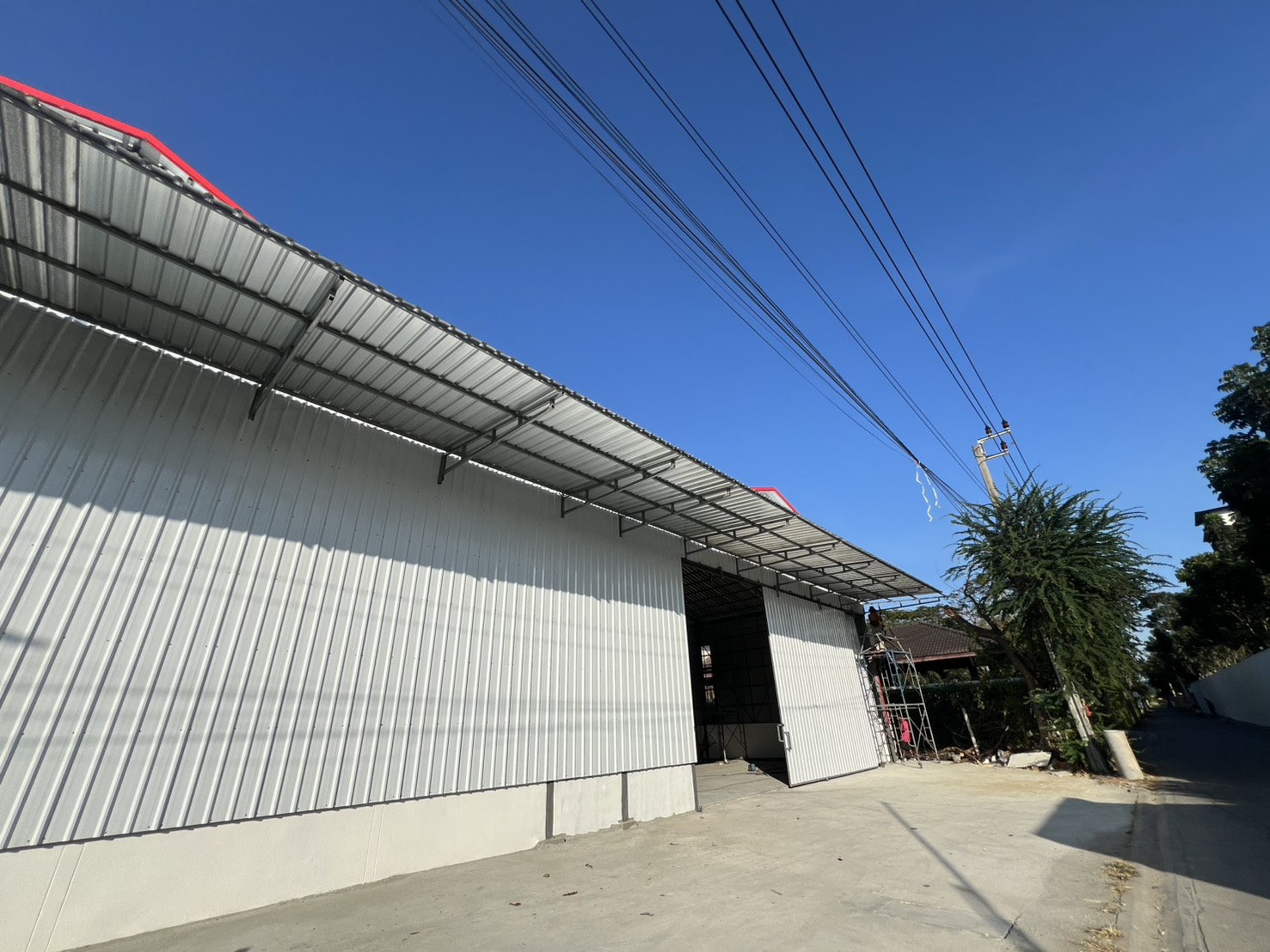 Warehouse for rent in Saphan Sung, Bangkok - Close-up of corrugated metal facade and canopy above sliding doors of the warehouse in Saphan Sung, Bangkok.