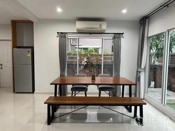 独立式住宅 出租在Suan Luang, Bangkok - 餐区，木质餐桌长椅，两侧皆有窗户