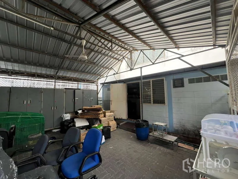 Office Space for rent - Backyard under metal canopy with lockers, chairs, and service rooms.