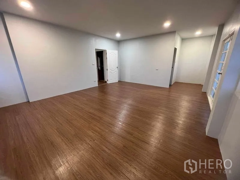 Detached House for sale in Bang Na, Bangkok - Large multipurpose room with wood floors, recessed lighting and white doors and windows.