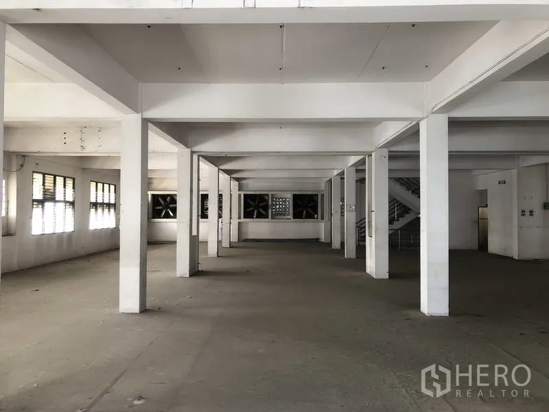 Factory for rent in Prawet, Bangkok - Ventilated work floor with large extractor fans and side windows.