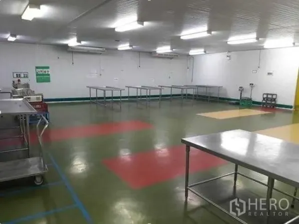 Factory for sale in Khlong Luang, Pathum Thani - Clean processing room with stainless worktables, epoxy flooring and bright strip lighting.