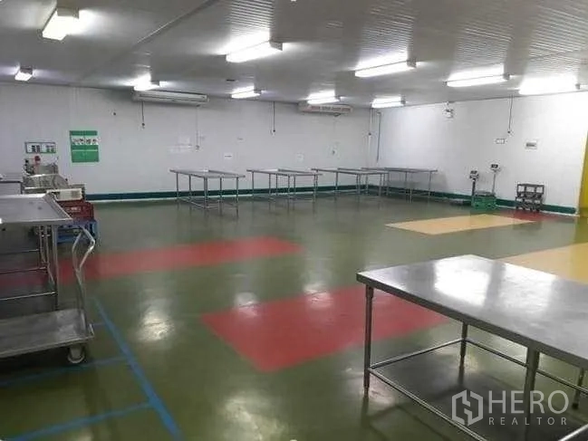 Factory for sale in Khlong Luang, Pathum Thani - Clean processing room with stainless worktables, epoxy flooring and bright strip lighting.