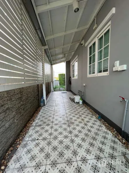独立式住宅 出租或出售在Khan Na Yao, Bangkok - 侧边有顶走道，花纹地砖与遮挡百叶，带生活工作区。