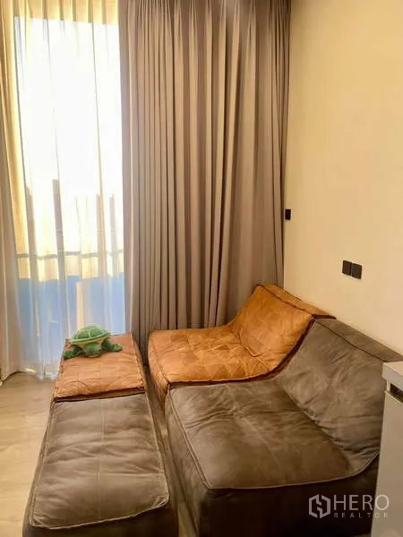 Condominium for rent - Bright living room with sectional sofa, sheer curtains and balcony at The Crest Park Residences, Chatuchak.