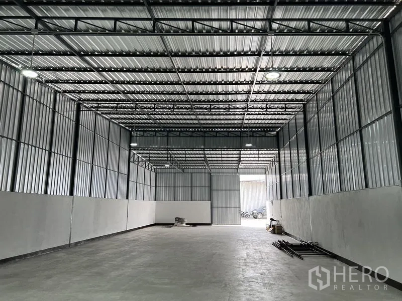 Warehouse for rent in Saphan Sung, Bangkok - Spacious warehouse interior with high steel truss roof, concrete floor and bright LED lighting