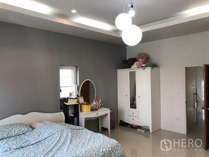 Detached House for sale in Lam Luk Ka, Pathum Thani - Bedroom with gray feature wall, pendant lights and white furniture.