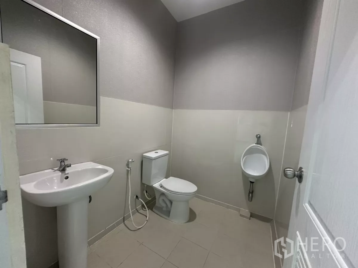 Factory for rent in Bang Phli, Samut Prakan - Modern restroom with pedestal sink, toilet and urinal.