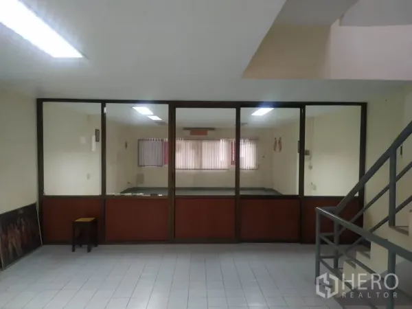 Home Office for rent in Yan Nawa, Bangkok - Lobby area facing a glass-partitioned meeting room, tiled floors and stair rail visible.