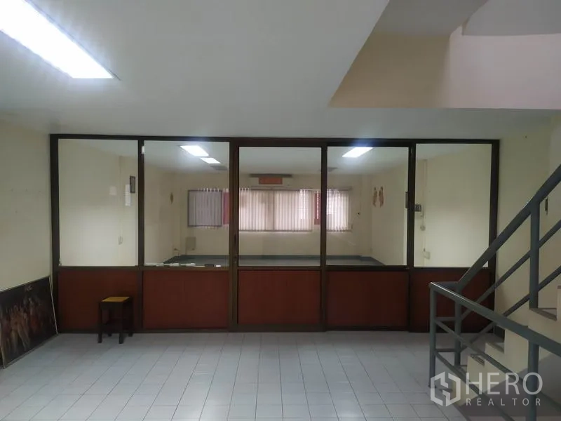 Home Office for rent in Yan Nawa, Bangkok - Lobby area facing a glass-partitioned meeting room, tiled floors and stair rail visible.