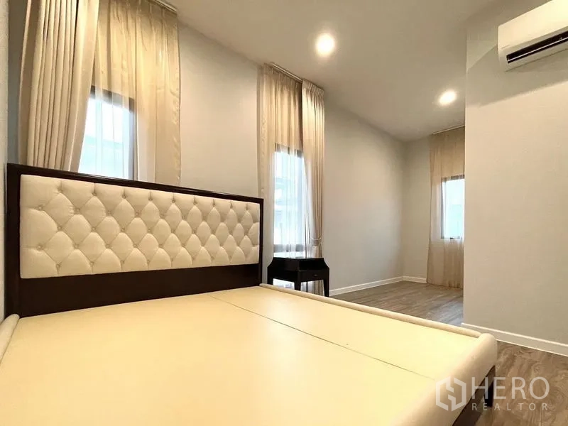 Detached House for rent in Bang Kapi, Bangkok - Secondary bedroom featuring tufted headboard, sheer curtains and recessed lights.