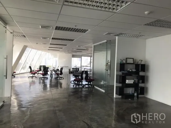 Office Space for rent in Khlong Toei, Bangkok - Spacious workspace featuring glass partitions, suspended ceiling lights, polished concrete flooring and rolling chairs.
