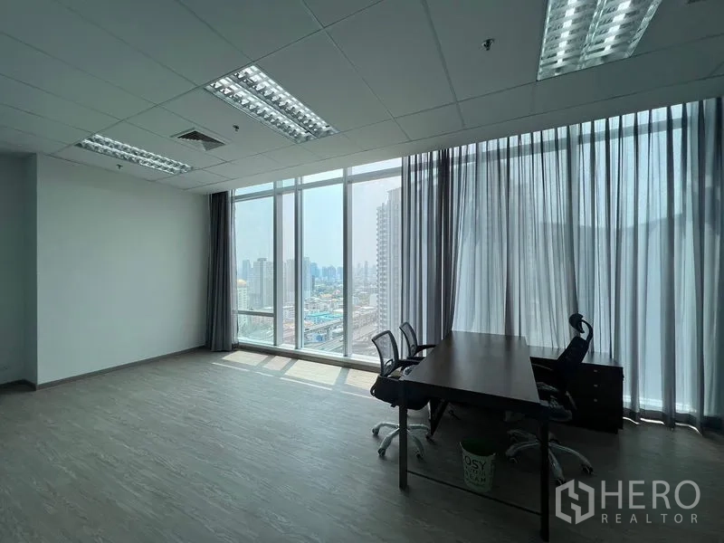 Office Space for rent - Workstation beside large panoramic windows with city views and abundant natural light.