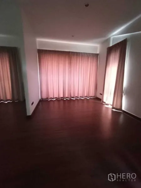 Home Office for rent in Watthana, Bangkok - Bedroom with dark wood floor and full-height curtains.