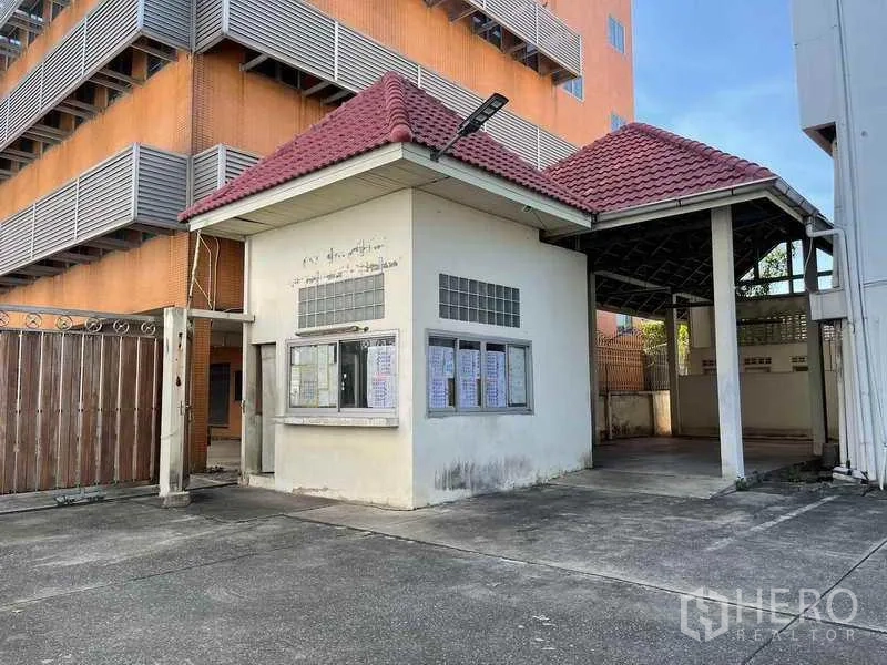 Factory for rent in Phra Samut Chedi, Samut Prakan - Security guardhouse with red‑tiled roof at the main entrance of the factory.