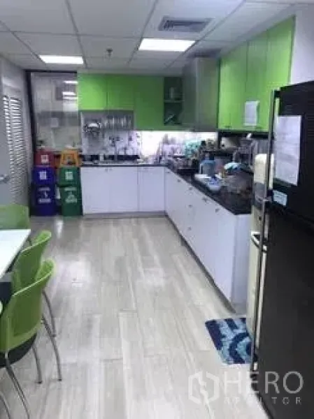 办公空间 出租在Khlong Toei, Bangkok - 办公室茶水间，绿色橱柜、洗手池、冰箱与用餐桌。