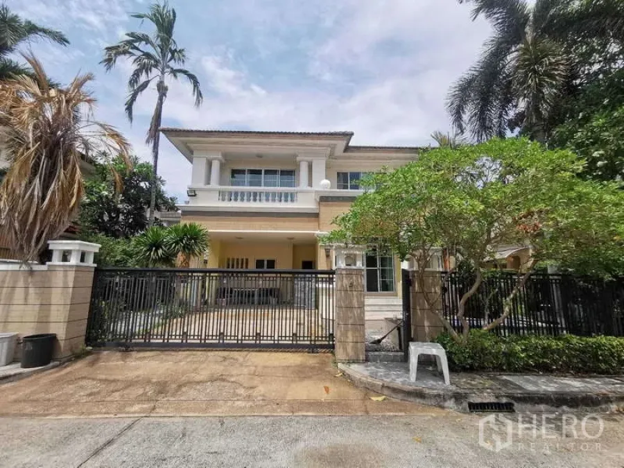 Detached House for rent - Two-storey detached house facade with a gated driveway, balcony, and mature tropical trees.