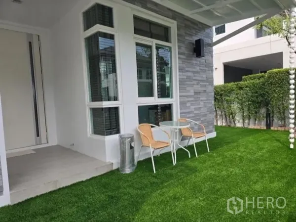 Detached House for rent - Front garden with small patio set beside bay window and stone-clad exterior wall.
