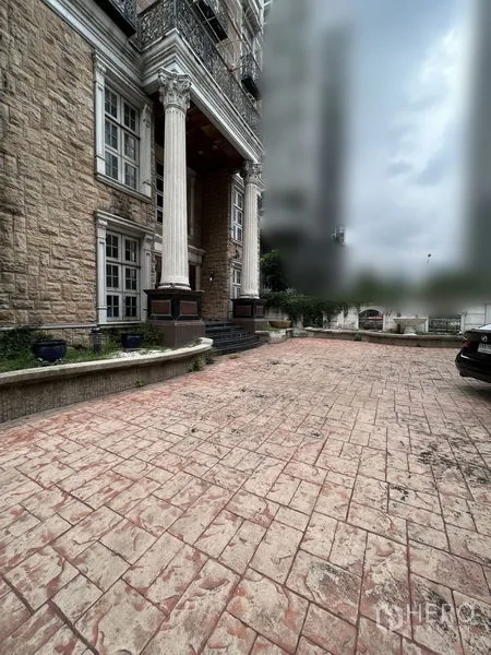 Home Office for rent in Huai Khwang, Bangkok - Stone-clad exterior with tall columns and a wide driveway offering on-site parking.