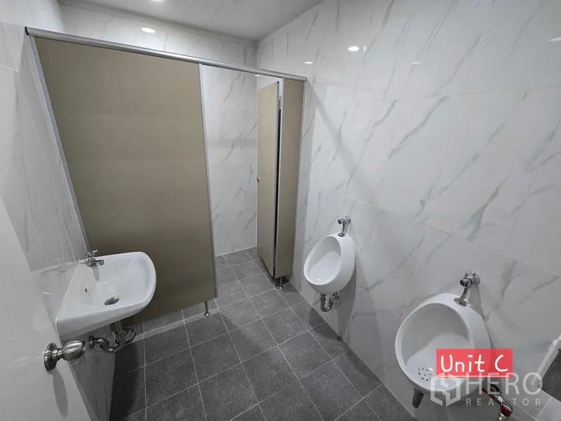 Home Office for rent in Chatuchak, Bangkok - Men’s restroom featuring two urinals, a sink, and a private stall.