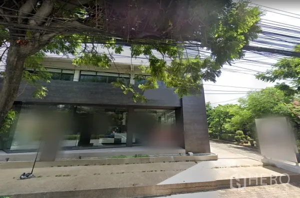Retail Space for rent in Suan Luang, Bangkok - Street view of the property’s wide glass storefront shaded by mature trees.