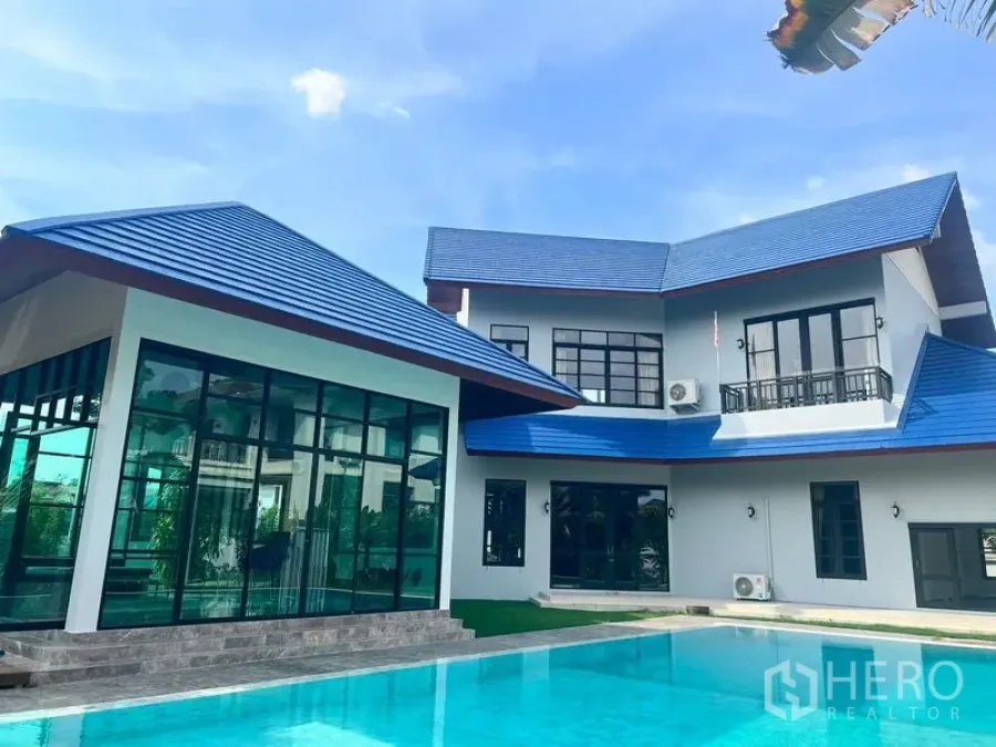 独立式住宅 出售在Prawet, Bangkok - 当代住宅外立面，蓝色屋顶倒映在泳池水面。