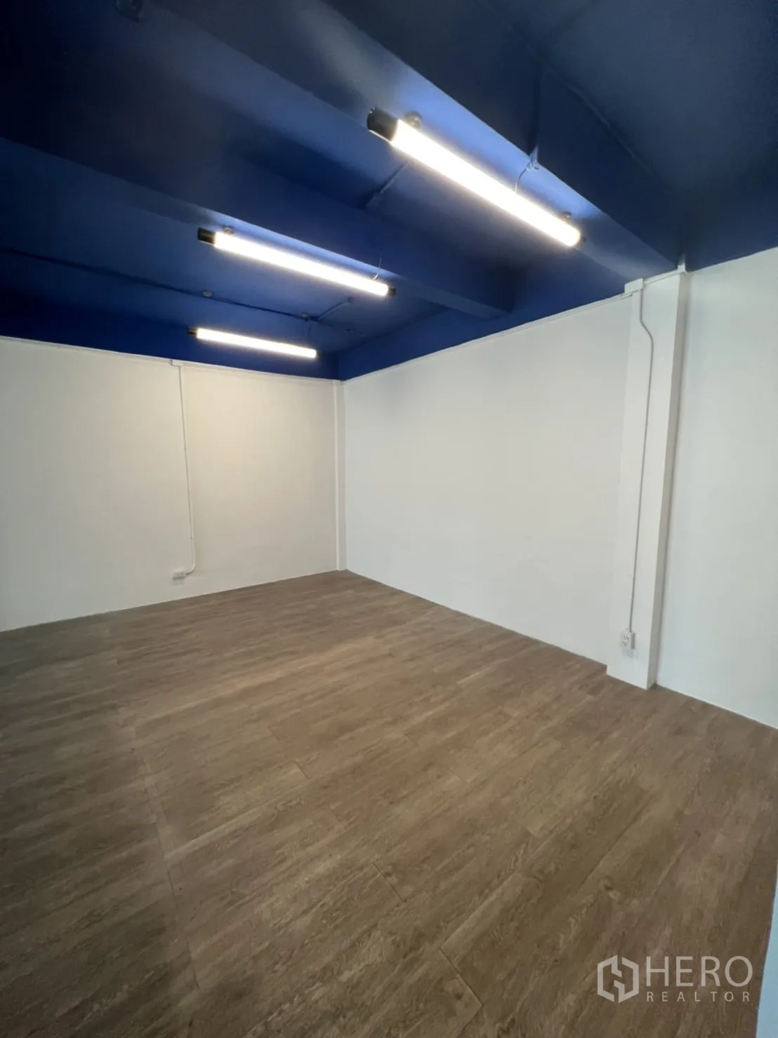Office Space for rent in Watthana, Bangkok - Private workspace zone with blue ceiling and warm wood-look floor.