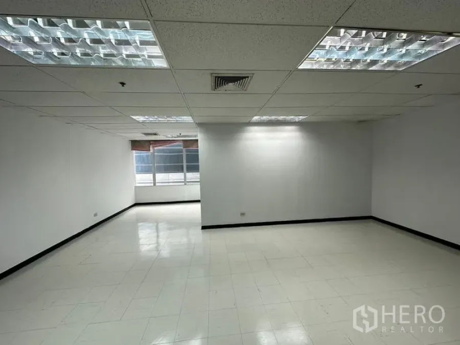 Office Space for rent in Chatuchak, Bangkok - Open-plan 55 sqm office with white walls, tiled flooring, grid ceiling with fluorescent lights, and a window for natural light in Chatuchak, Bangkok.