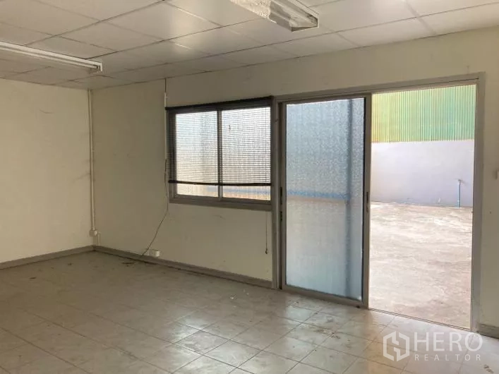 Factory for rent in Bang Sao Thong, Samut Prakan - Office room with tiled floor, window blinds and sliding glass door.