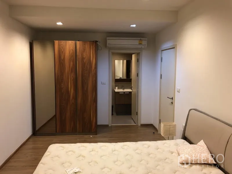 Condominium for rent in Watthana, Bangkok - Master bedroom showing wardrobe, air-conditioning and entrance to the ensuite bathroom.