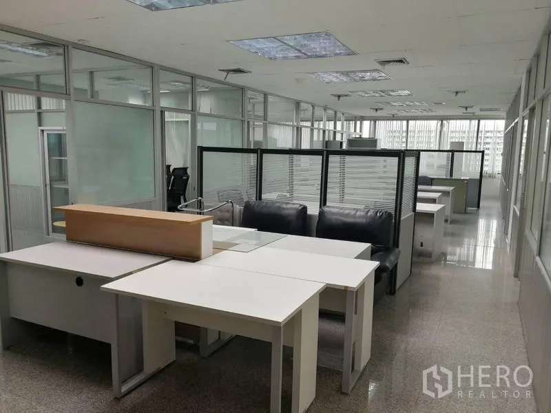 Office Space for rent in Bang Na, Bangkok - Reception counter and sofa seating next to partitioned workstations in a large office.