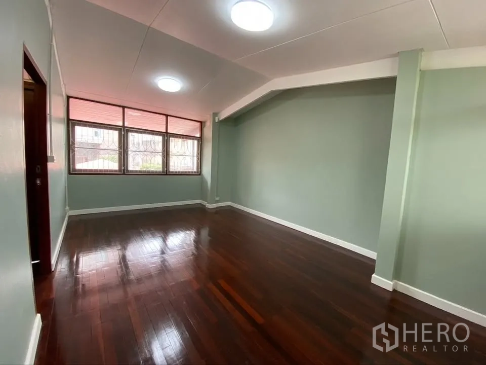 独栋房屋 for rent in Suan Luang, Bangkok - 宽阔卧室，绿色墙面与光亮木地板并设窗户采光。